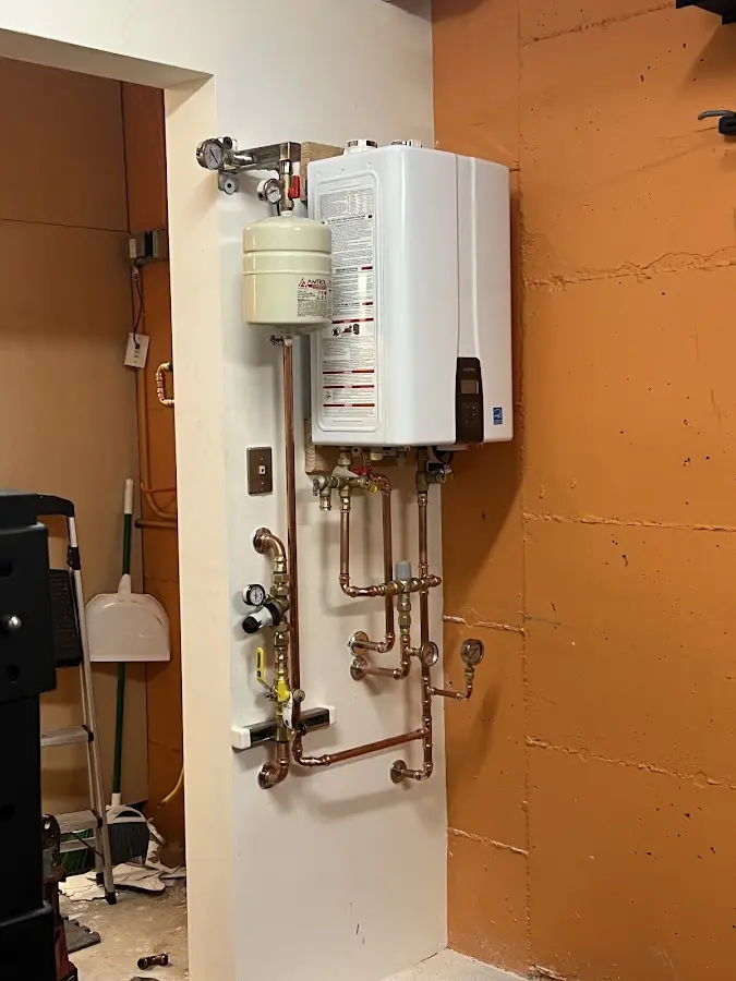 Plumbing technician inspecting water heater connections in Redan